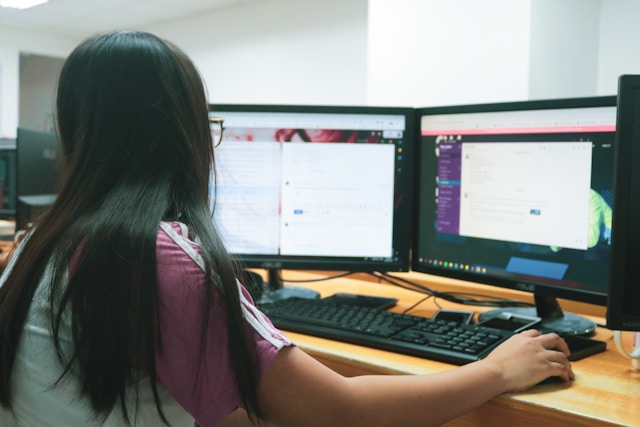 Secretary working on a computer with two monitors